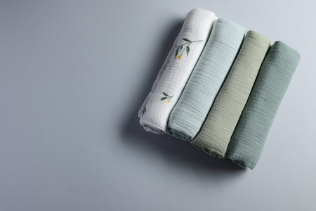 Rolled baby blankets on light grey background, flat lay. Space for textの写真素材