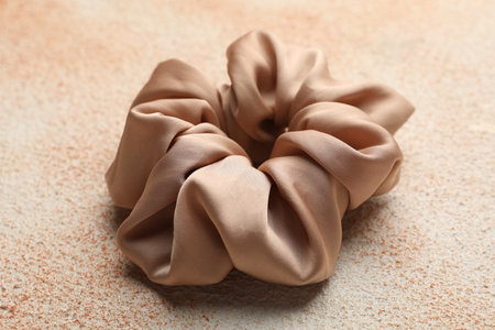 Beautiful hair scrunchie on color textured table, closeupの写真素材