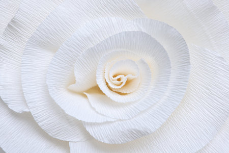 Beautiful white paper flower as background, top view