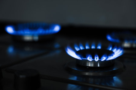 Gas burners with blue flame on stove, closeupの写真素材