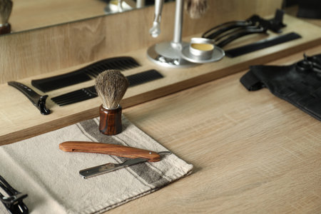 Many different barber's tools on light wooden table in barbershopの写真素材