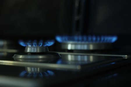 Gas burners with blue flame on stove, closeupの写真素材