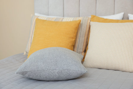 Soft decorative pillows on bed in bedroom