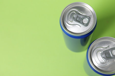 Two tin cans on light green background, closeup. Space for textの写真素材