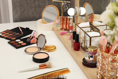 Makeup room. Different beauty products on white dressing table and mirror indoors, closeupの写真素材