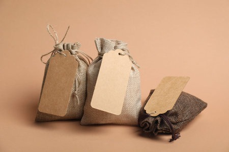Burlap bags with tags on beige backgroundの写真素材