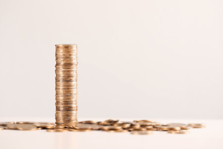 Shiny coins on white table against light background, closeup. Space for textの写真素材