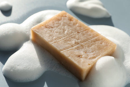 Soap bar with foam on grayish blue background, closeupの写真素材