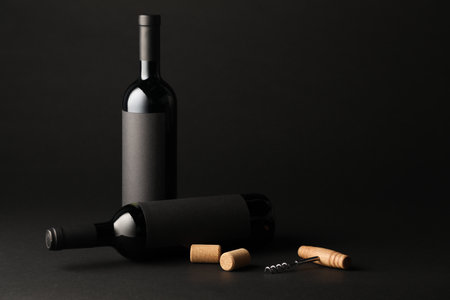 Bottles of wine, corks and corkscrew on black backgroundの写真素材