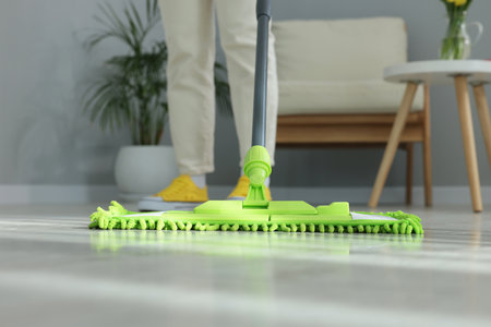 Woman cleaning floor with microfiber mop indoors, closeupの写真素材