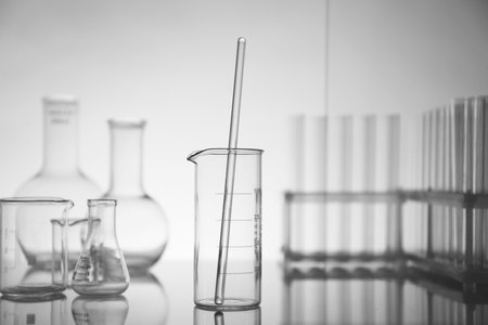Laboratory glassware on mirror surface against light backgroundの写真素材