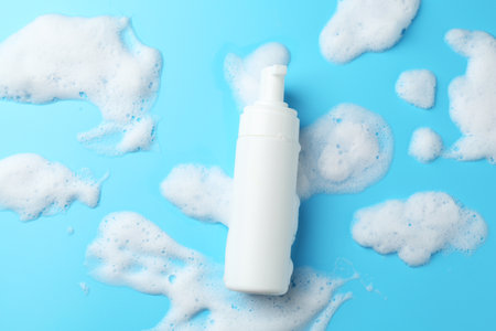 Bottle of cosmetic product with foam on light blue background, top viewの写真素材