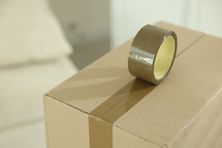 Sealing cardboard box with adhesive tape indoors, closeupの写真素材