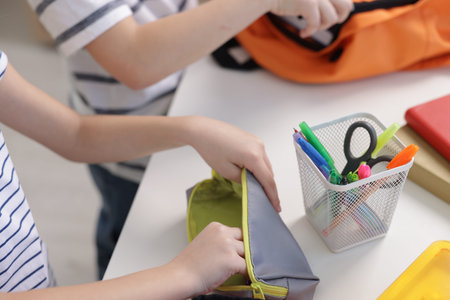 Kids getting ready for school at table indoors, closeup