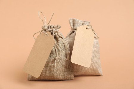 Burlap bags with tags on beige backgroundの写真素材