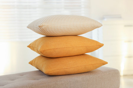 Stacked decorative pillows on sofa in roomの写真素材
