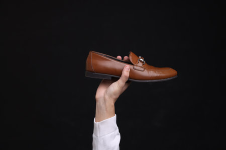 Man with stylish shoe on black background, closeupの写真素材