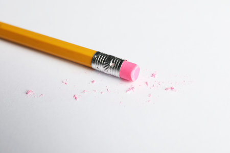 Pencil with eraser and scraps on white sheet of paper, closeupの写真素材