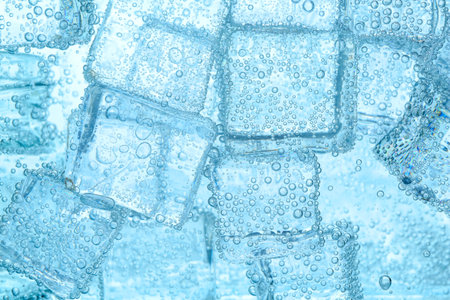 Refreshing soda water with ice cubes as background, closeupの写真素材