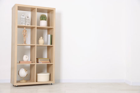 Shelving unit with different home decor near white wall indoors, space for textの写真素材