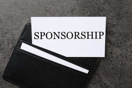 Business card with word Sponsorship in black holder on grey table, top viewの写真素材