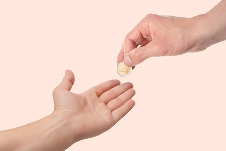 Sponsor giving coin to man on beige background, closeupの写真素材