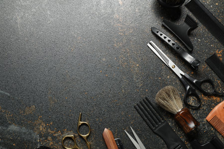 Many different barber's tools on black textured table, flat lay. Space for textの写真素材