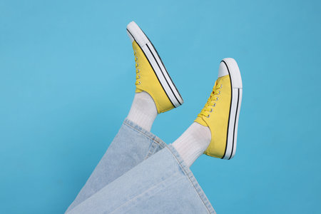 Woman wearing stylish sneakers on light blue background, closeupの写真素材
