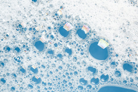 Detergent foam with bubbles on light blue background, top viewの写真素材