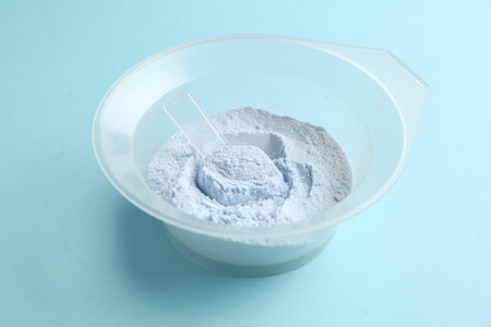 Bowl with hair bleaching powder on light blue background, closeupの写真素材