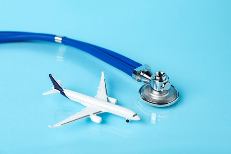 Stethoscope and airplane model on light blue background, closeupの写真素材