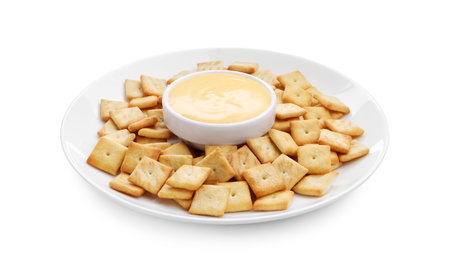 Tasty cheese dipping sauce in bowl and crackers isolated on whiteの写真素材