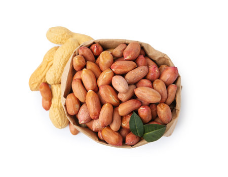 Fresh peanuts in paper bag and unpeeled ones isolated on white, top viewの写真素材