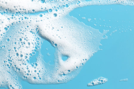Detergent foam with bubbles on light blue background, top viewの写真素材
