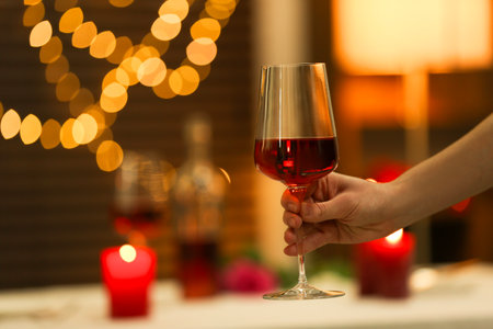 Romantic dinner. Woman with glass of red wine in restaurant, closeup. Space for textの写真素材
