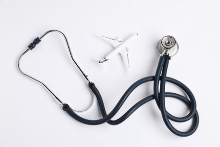 Stethoscope and airplane model on light background, flat layの写真素材