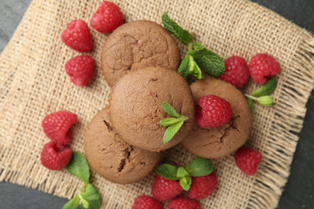 Delicious muffins with raspberries and mint on dark textured table, top viewの写真素材