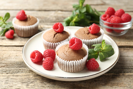 Delicious muffins with raspberries and mint on wooden table, closeupの写真素材