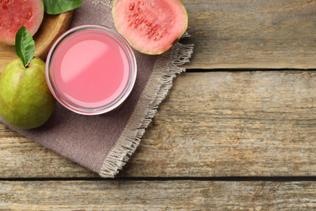 Refreshing guava juice and fresh fruits on wooden table, flat lay. Space for textの写真素材