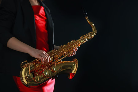 Professional musician with saxophone on black background, closeupの写真素材