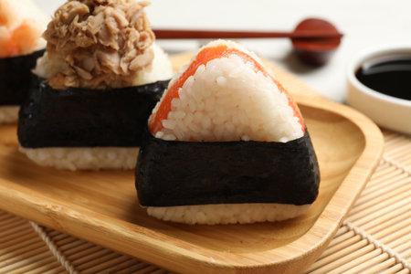 Tasty onigiri (Japanese rice balls) served on white table, closeup