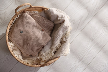 Baby blankets in basket on floor, top view. Space for textの写真素材