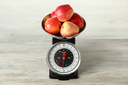 Retro mechanical kitchen scale with apples on wooden tableの写真素材