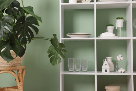 Shelving unit with dishware near olive wall indoorsの写真素材