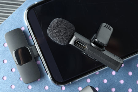 Lavalier microphone, smartphone with wireless receiver and notebook on table, top viewの写真素材