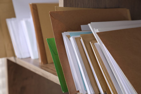 Different paper envelopes on shelf in post office, closeup. Space for text