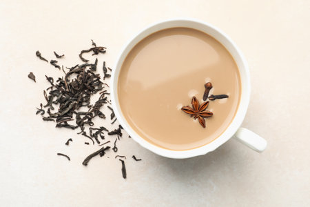 Aromatic Masala tea in cup, dry leaves and spices on light grey table, flat layの写真素材