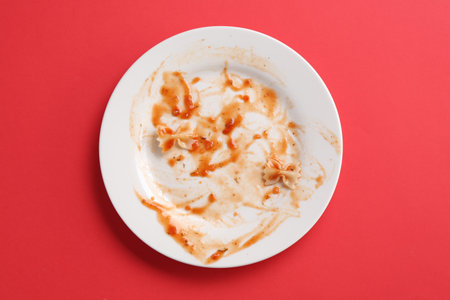 Dirty plate on red background, top viewの写真素材