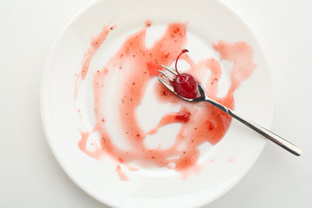 Dirty plate and fork on white background, top viewの写真素材