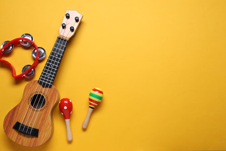 Different toy musical instruments on orange background, flat lay. Space for textの写真素材
